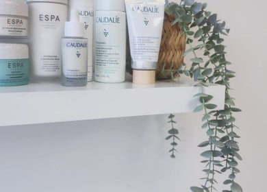 Skincare products on a shelf at Kintsugi Beauty & Holistics, Newton Abbot, England, GB with decorative plant.