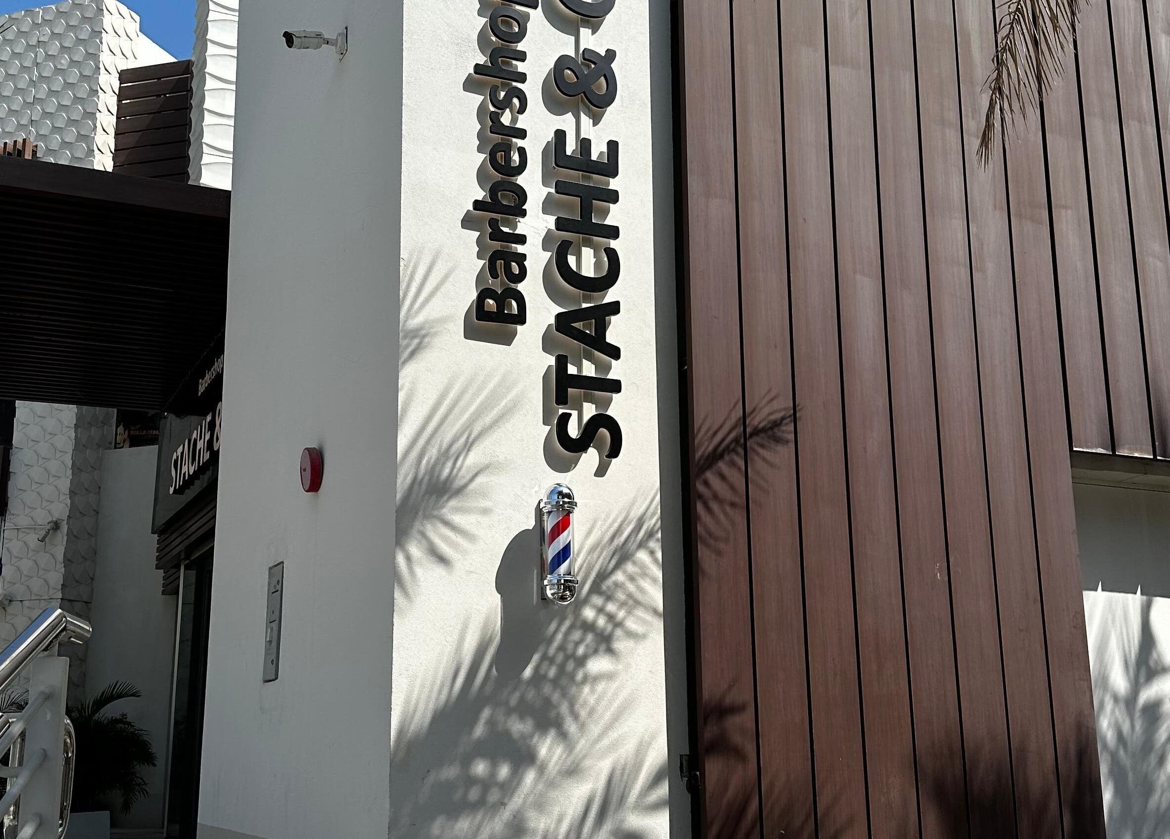 Front of Stache & Co. Barbershop - Reem Central Park, Abu Dhabi, with logo on modern exterior.