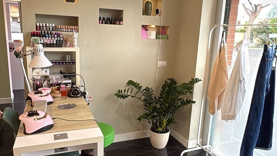 Interno elegante di Evelyn Lash & Permanent Makeup a Lazio, Lazio, IT con postazione manicure e pianta verde.