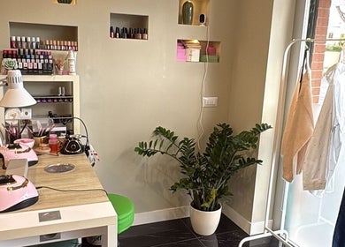 Interno elegante di Evelyn Lash & Permanent Makeup a Lazio, Lazio, IT con postazione manicure e pianta verde.