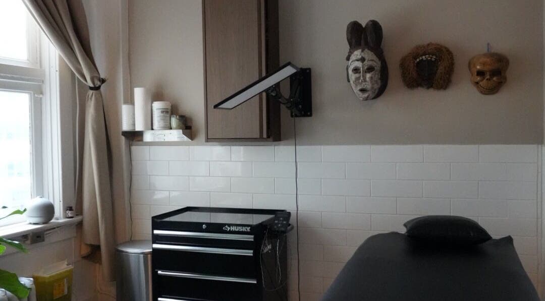 La Caverne's tranquil therapy room featuring mask wall art in Calgary, Alberta, CA.