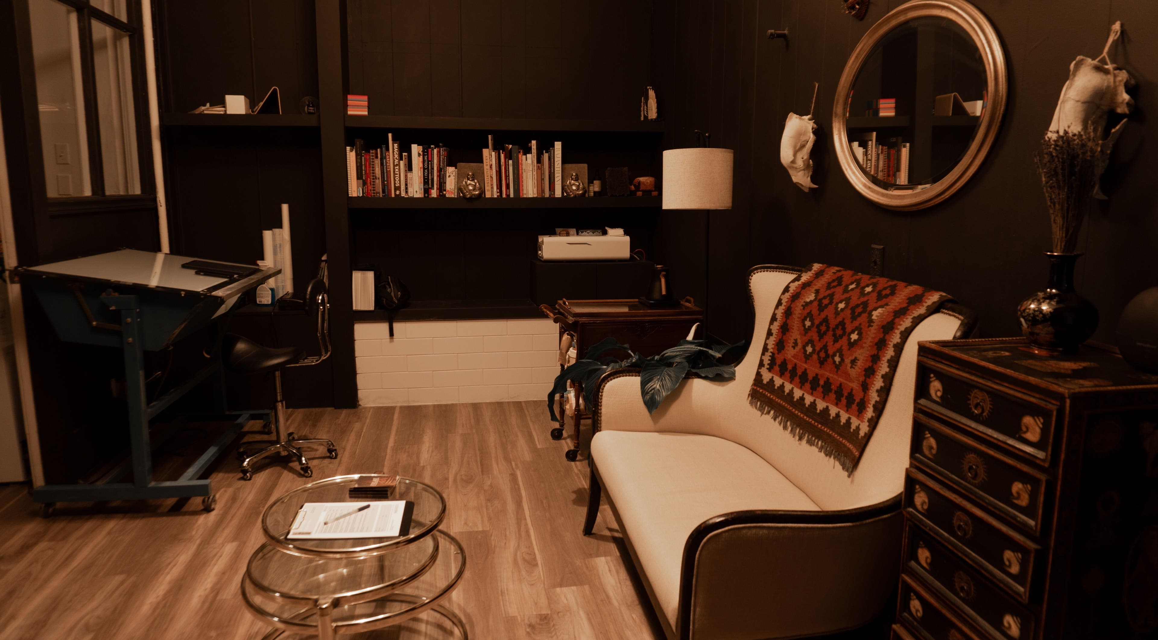 Elegant reading nook at La Caverne, Calgary, Alberta, CA with a plush sofa and artful decor showcasing comfort.