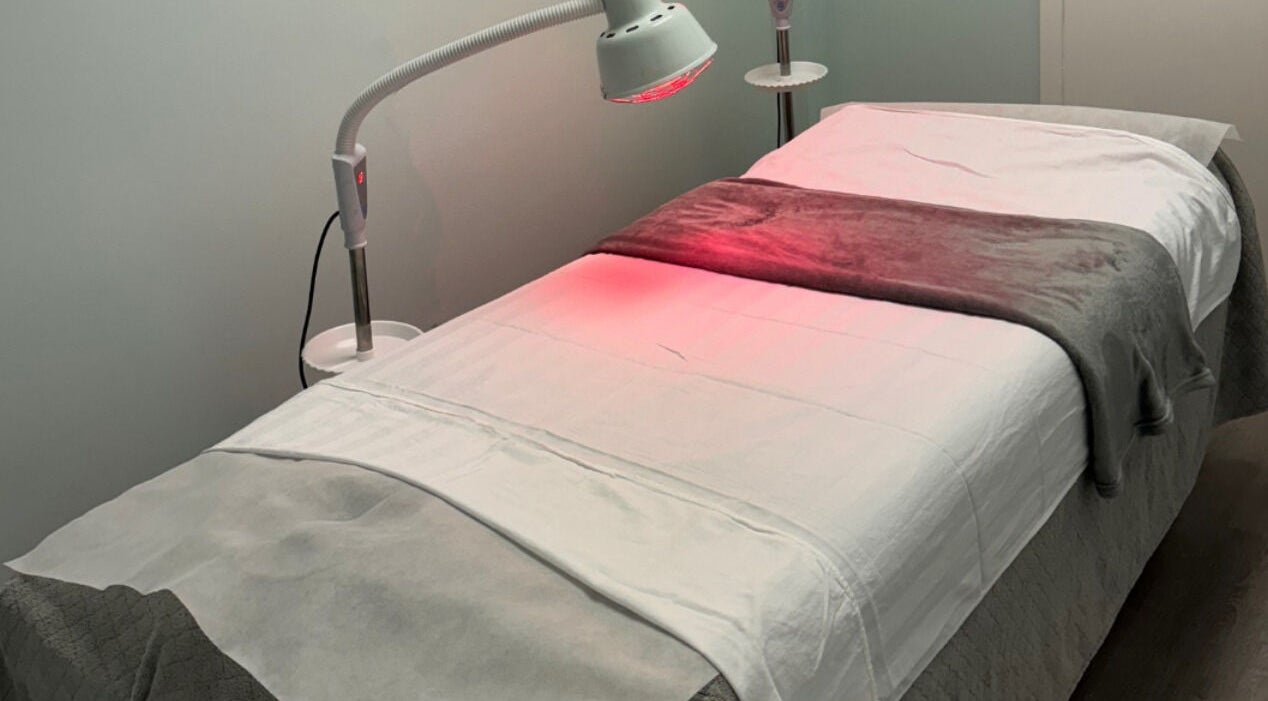 Comfortable treatment bed at Li Wellness Acupuncture in New York, New York, US, with warm lighting.