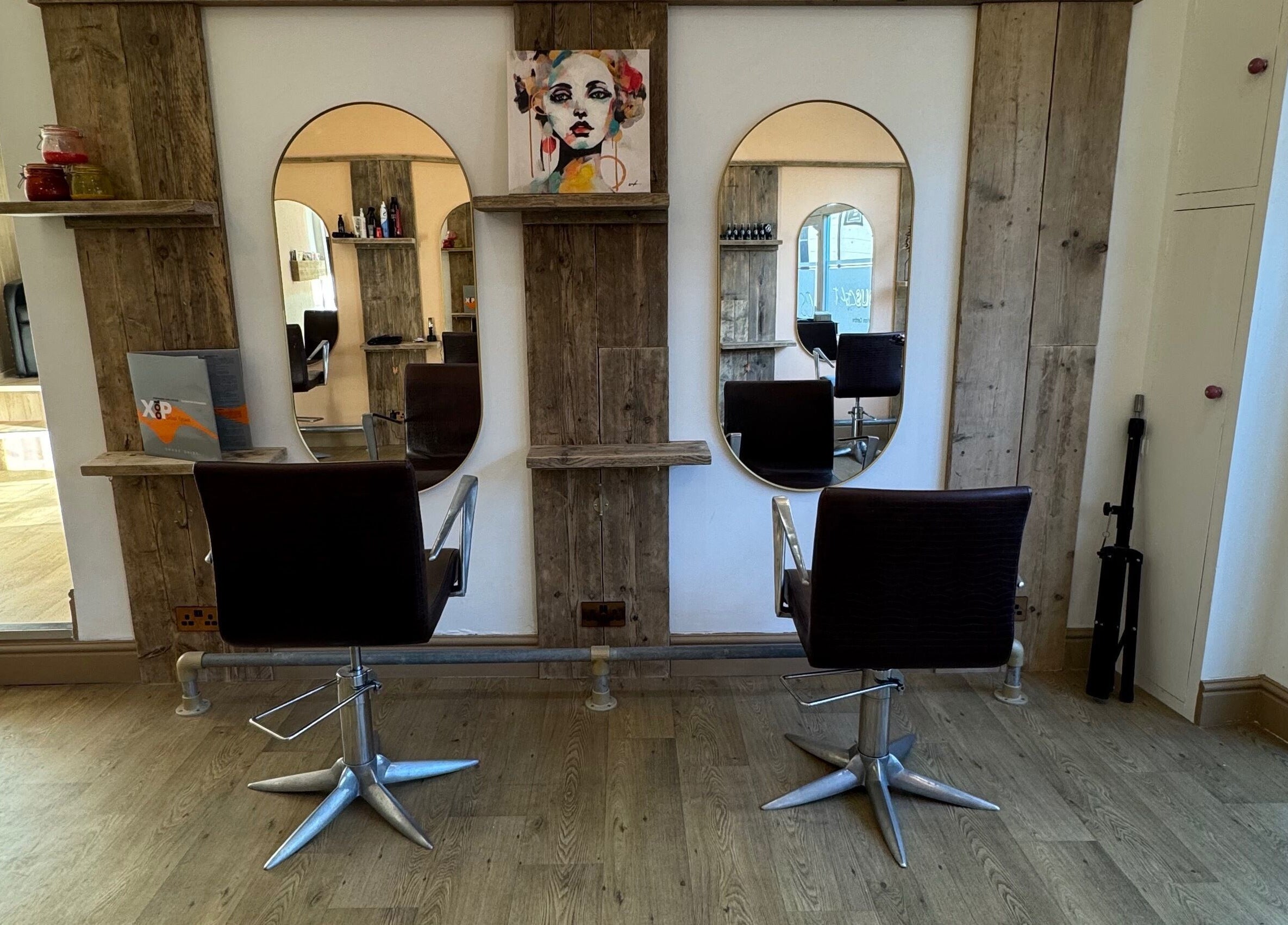 Elegant salon stations at The Curious Stylist in Bovey Tracey, England, GB featuring stylish mirrors and chairs.