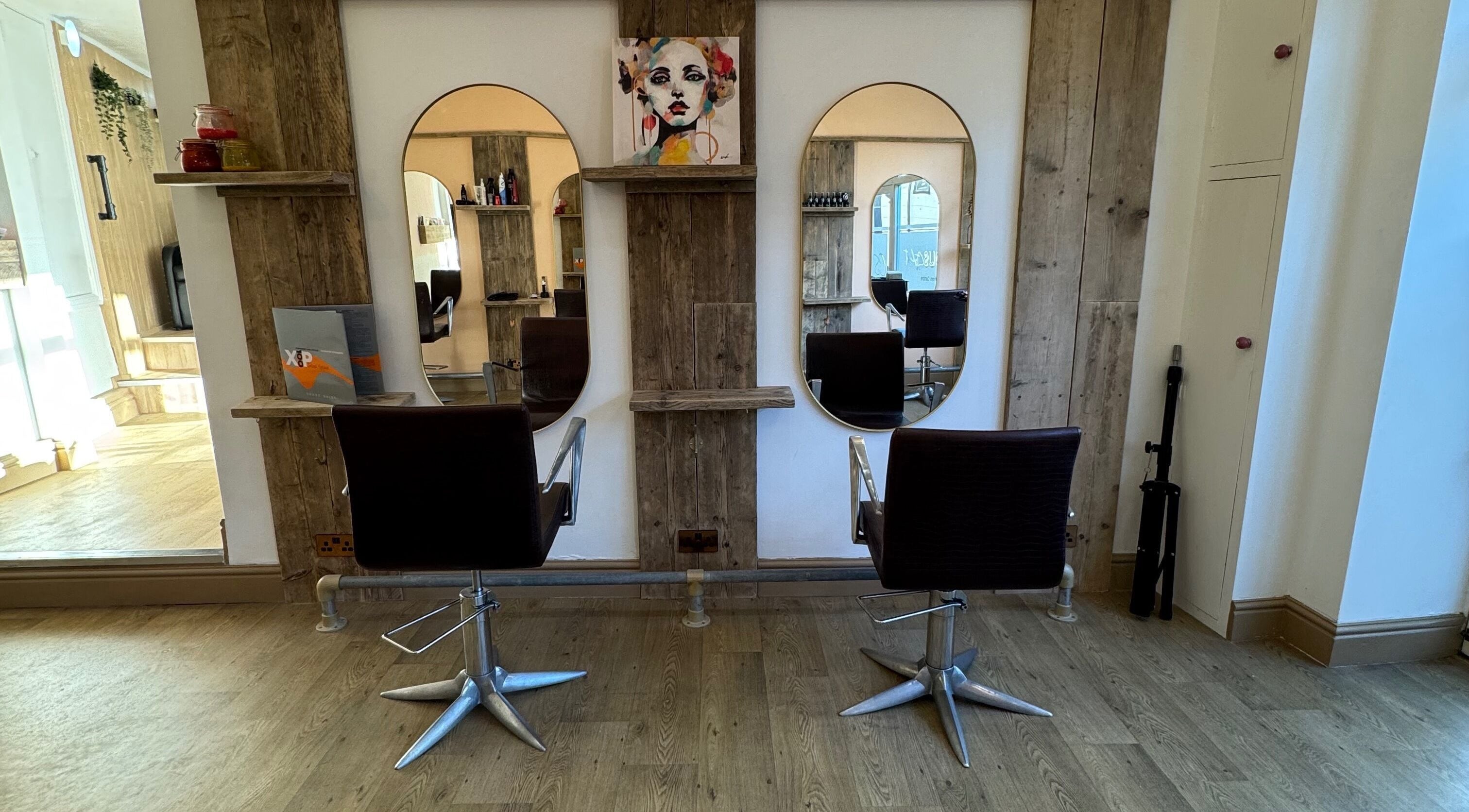 Elegant salon stations at The Curious Stylist in Bovey Tracey, England, GB featuring stylish mirrors and chairs.