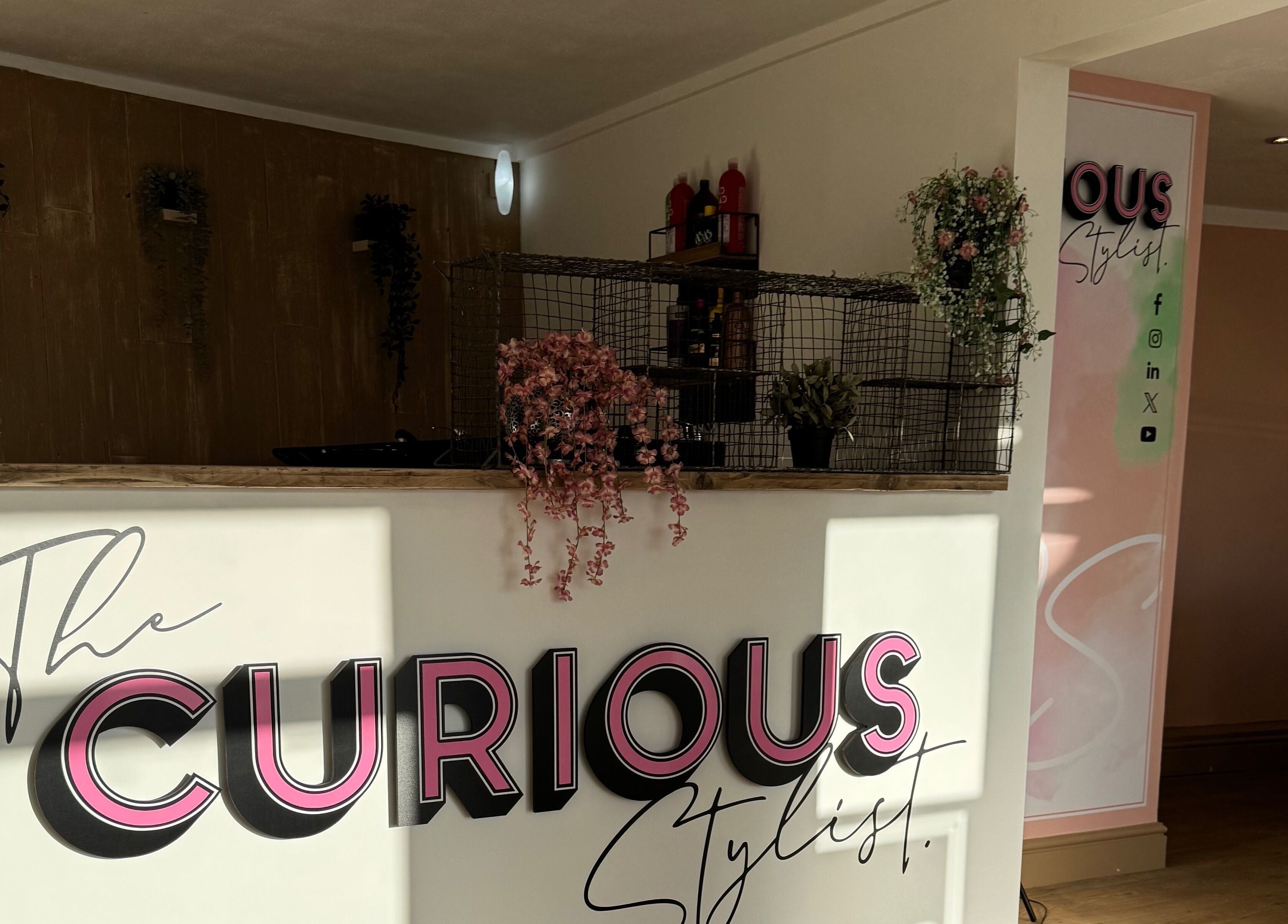 Reception of The Curious Stylist in Bovey Tracey, England, GB with stylish decor and branding.