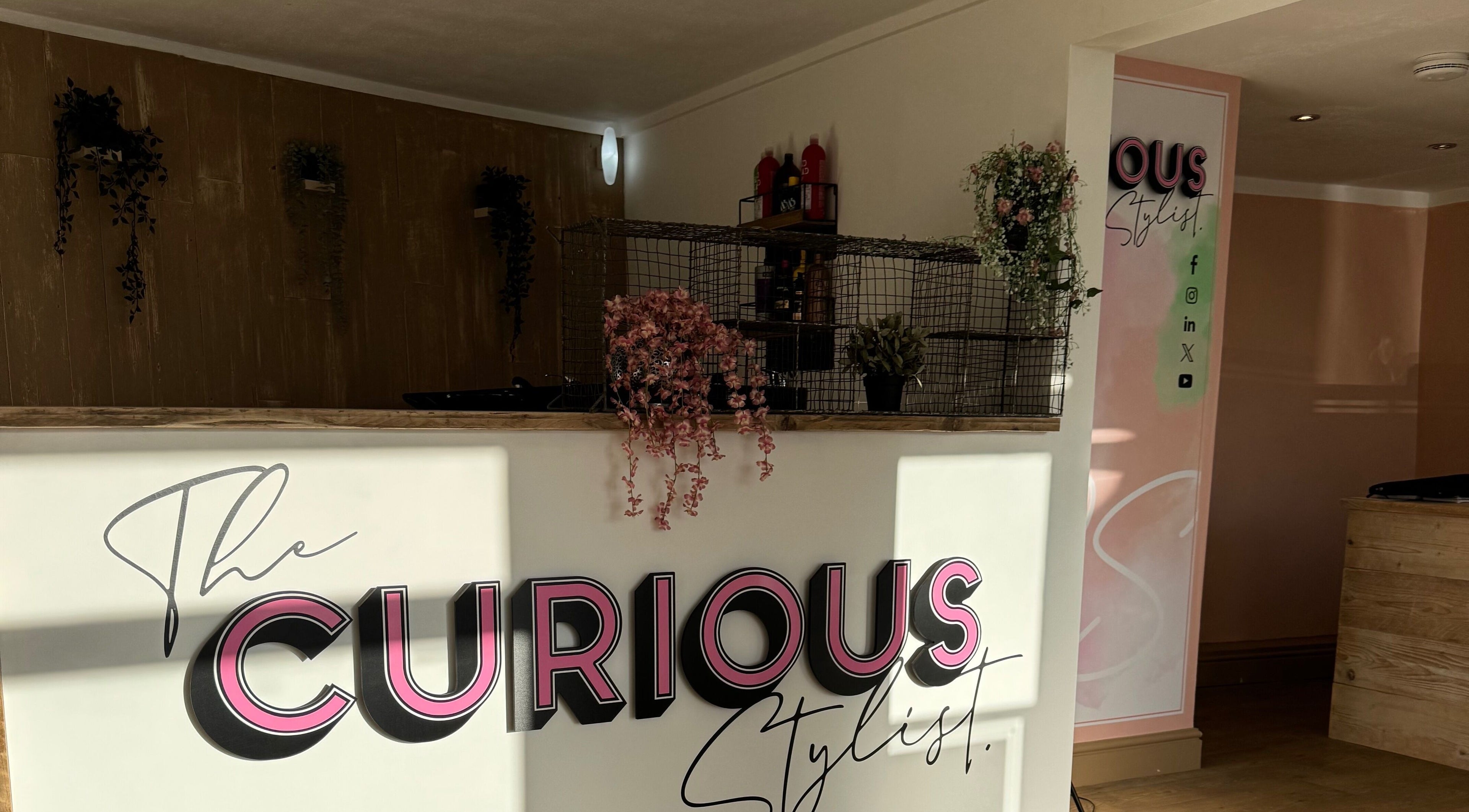 Reception of The Curious Stylist in Bovey Tracey, England, GB with stylish decor and branding.