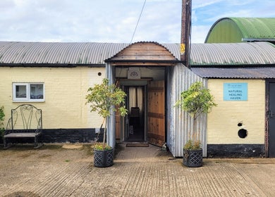 Front entrance of Balance and Heal, Royston, England with rustic decor inviting visitors inside.