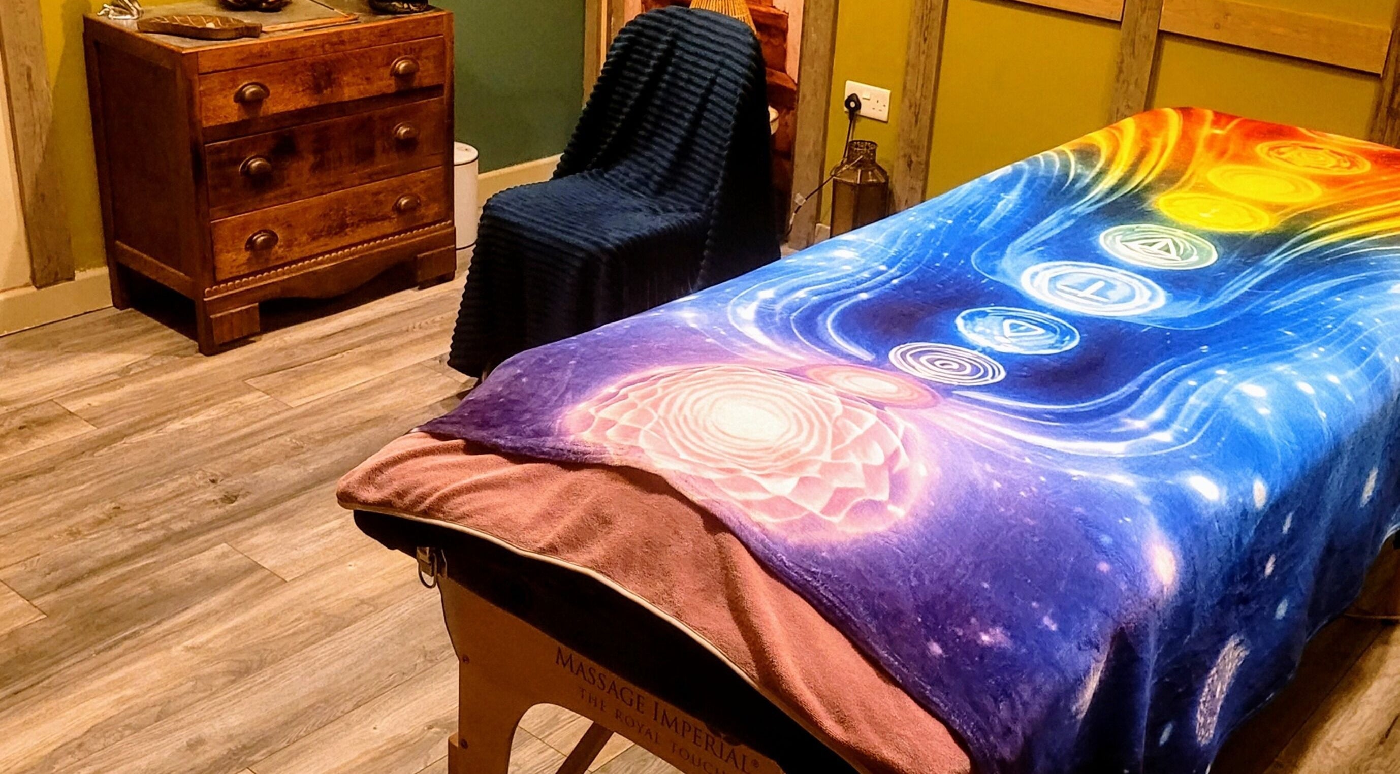 Serene massage room at Balance and Heal, Royston, England, GB, featuring colorful chakra blanket.
