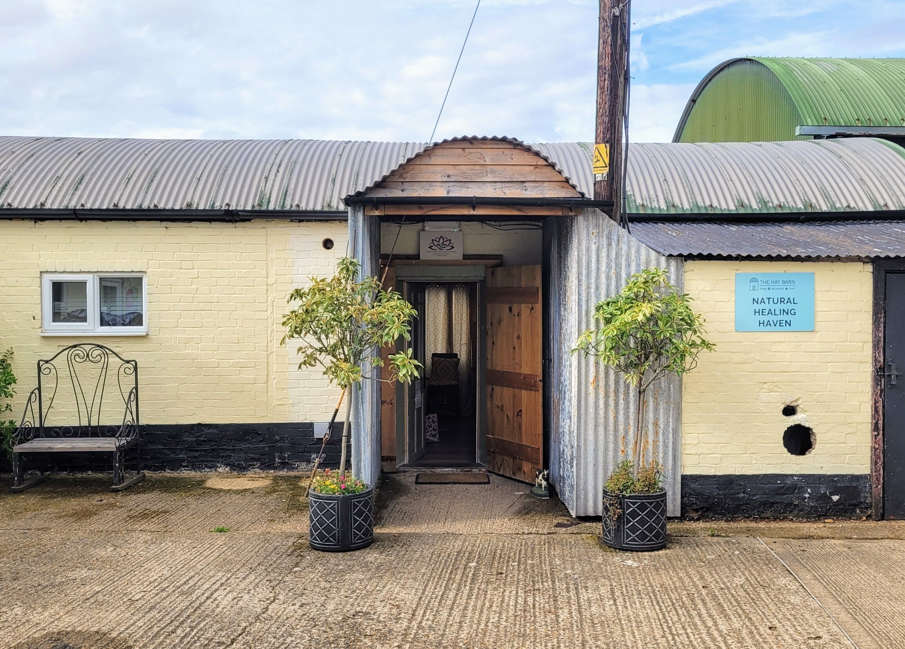 Entrance to Balance and Heal in Royston, England, GB featuring rustic design and greenery.