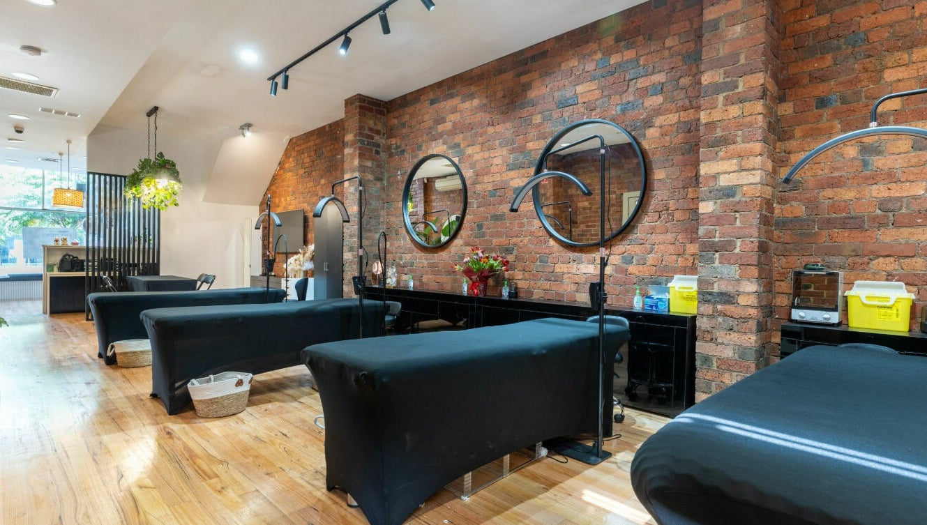 Chic interior of Tulip Beauty Lash and Brow in Melbourne, Victoria, AU with stylish treatment beds and brick walls.