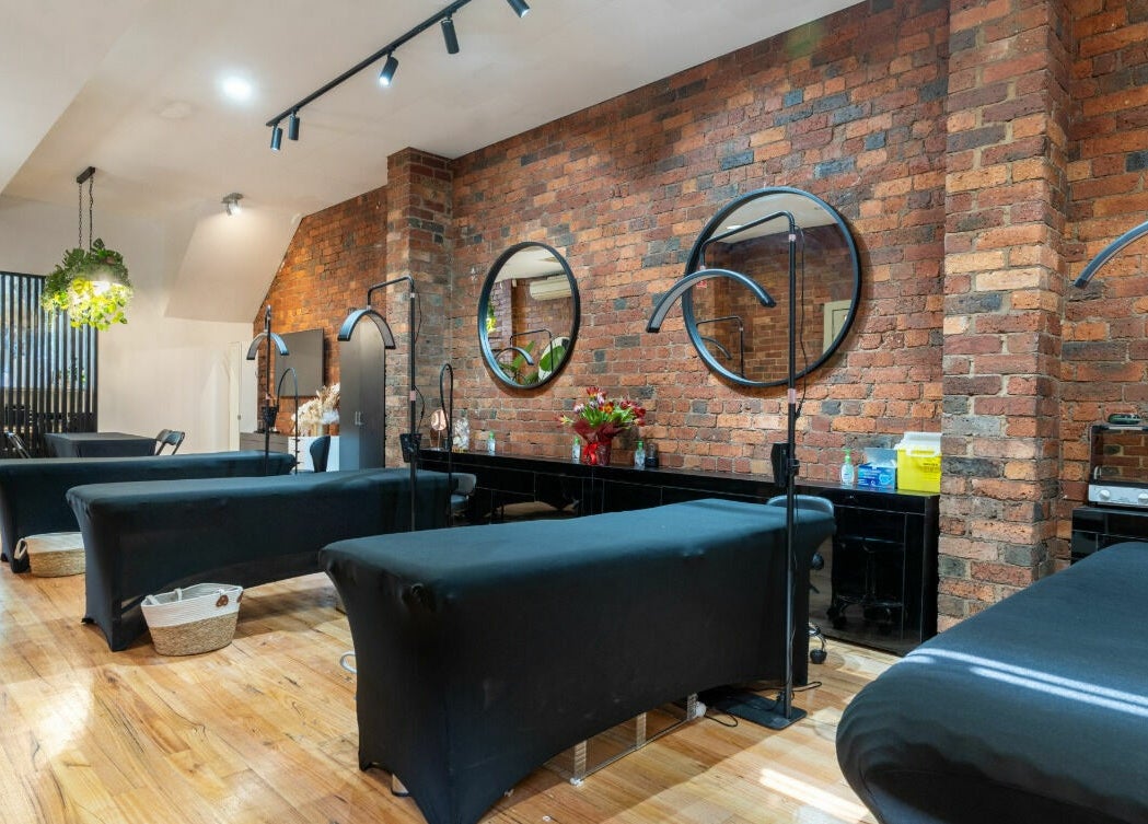 Chic interior of Tulip Beauty Lash and Brow in Melbourne, Victoria, AU with stylish treatment beds and brick walls.