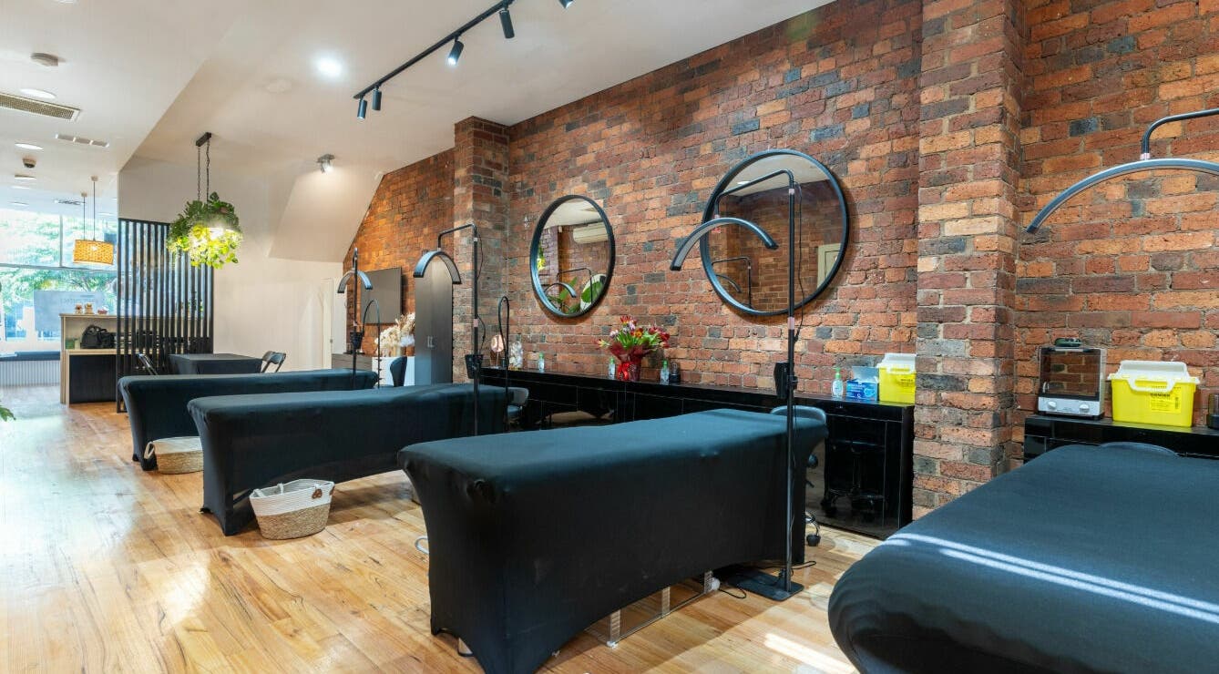 Chic interior of Tulip Beauty Lash and Brow in Melbourne, Victoria, AU with stylish treatment beds and brick walls.