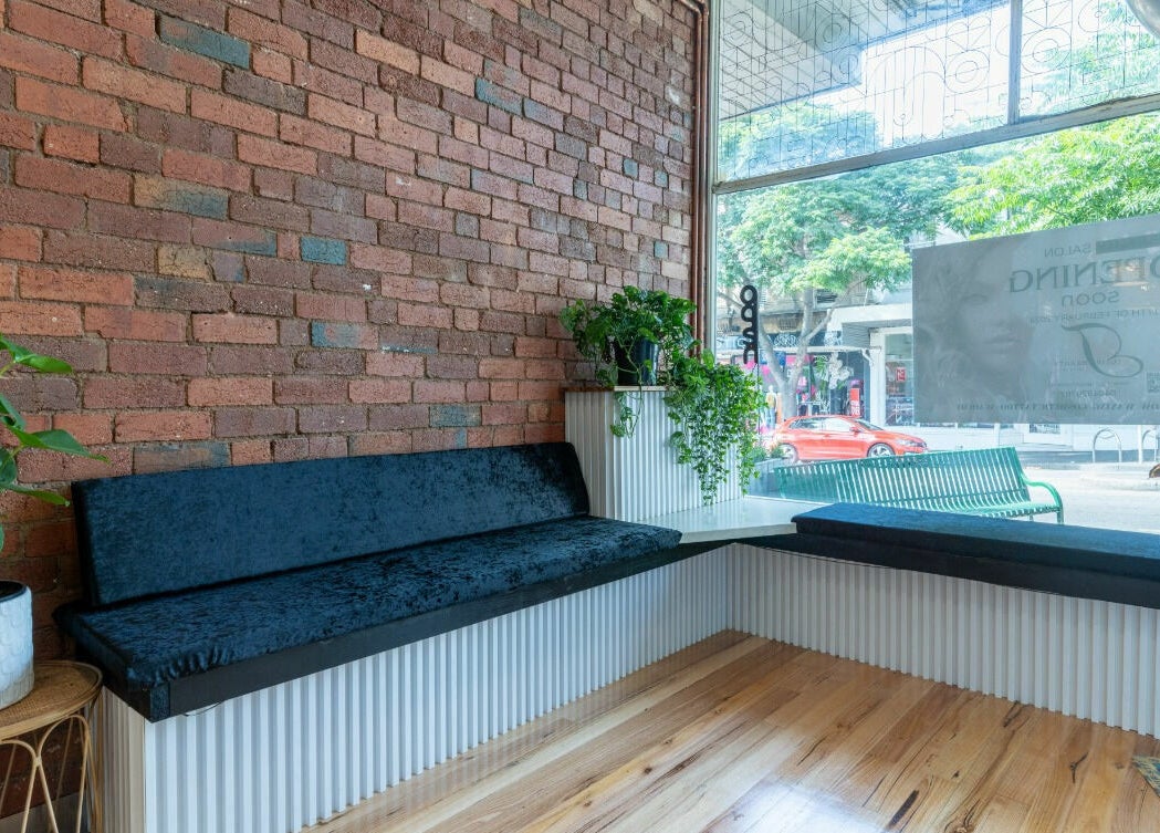 Inviting seating area at Tulip Beauty Lash and Brow in Melbourne, Victoria, AU, featuring plants and brick walls.