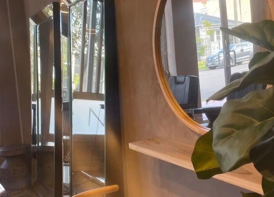 Elegant interior of Nikola Krstev Salon in Wollongong, New South Wales, AU with stylish mirrors and plants.
