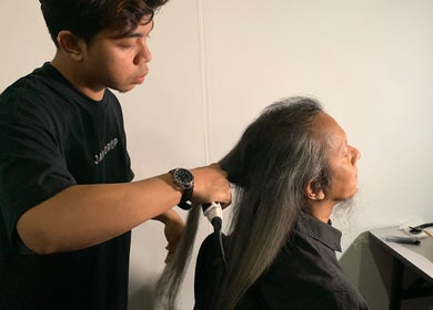 Stylist at THE CUT ONE in Klang, Selangor, MY expertly treats long hair for a client.