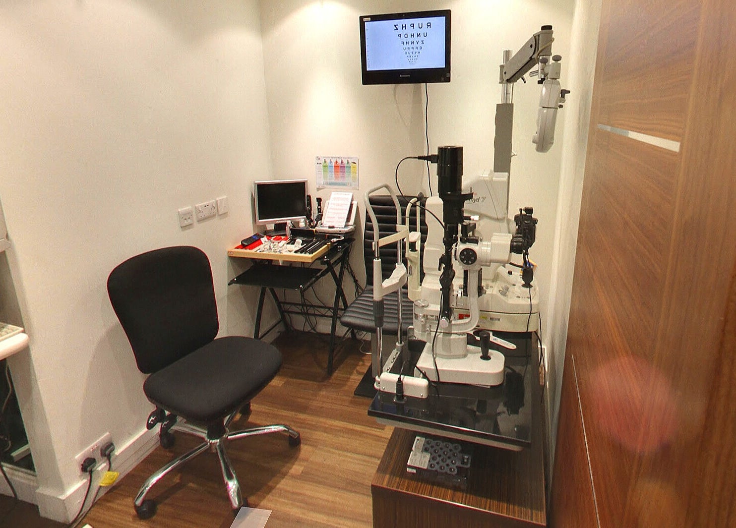 A cozy examination room at M S Kalsi Opticians - Banstead, Banstead, GB, featuring an eye test setup.