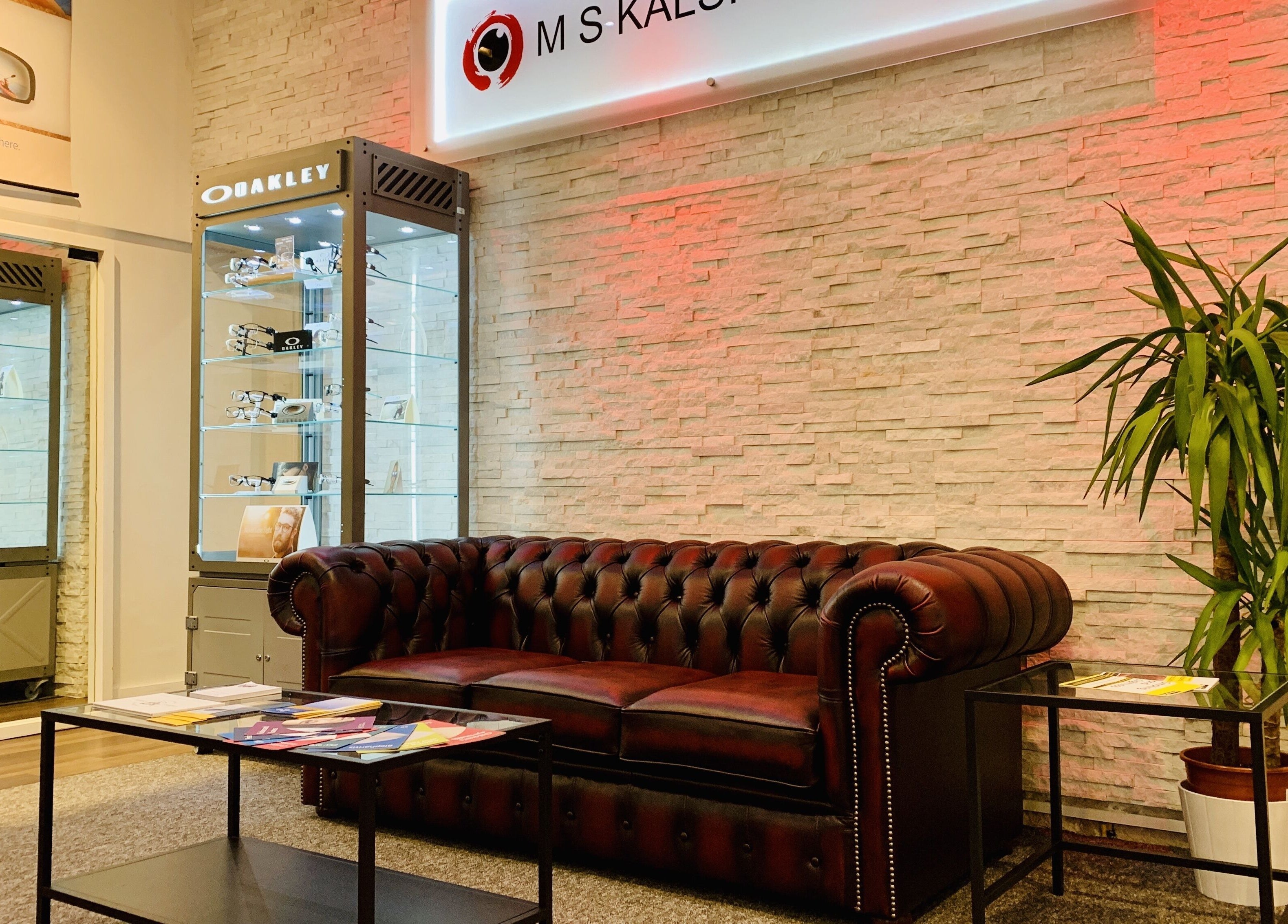 Chic waiting area in M S Kalsi Opticians - Banstead with leather sofa and eyewear displays. Banstead, GB.
