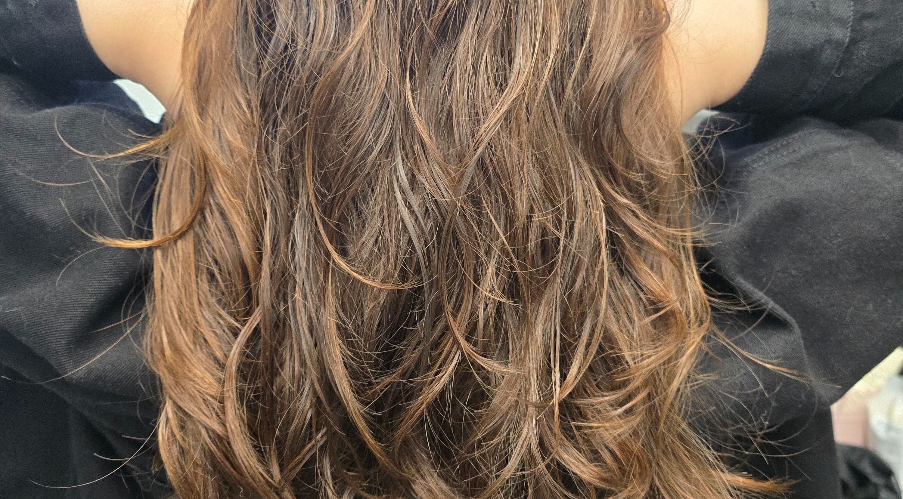 Close-up of styled brown hair at Eternal Young Salon in Calgary, Alberta, CA, showcasing vibrant highlights.