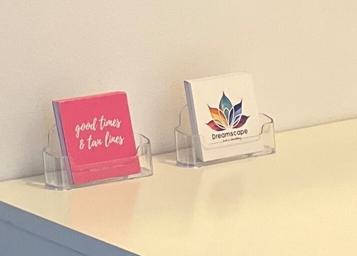 Business cards for Good Times & Tan Lines, Runaway Bay, Queensland, AU, elegantly displayed on a counter.