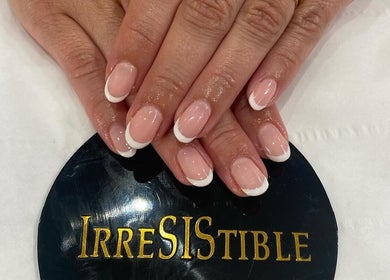 Elegant French manicure at IrreSiStible Hair & Beauty, Exeter, England, GB. Perfect nails on a stylish display.