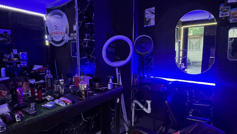 Interior moderno de Barber Studio Crisanto en Villa Nueva, Guatemala, GT, con iluminación neón y espejos.