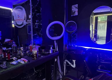 Interior moderno de Barber Studio Crisanto en Villa Nueva, Guatemala, GT, con iluminación neón y espejos.