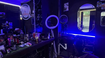 Interior moderno de Barber Studio Crisanto en Villa Nueva, Guatemala, GT, con iluminación neón y espejos.