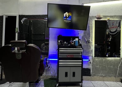 Interior de Barber Studio Crisanto en Villa Nueva, Guatemala, GT con silla y espejo iluminado.