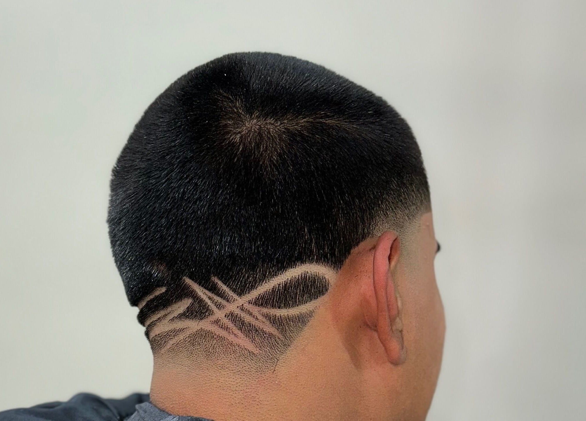 Creative hair design at Charro Barber, Montebello, California, US, showcasing artistic fade and line patterns.