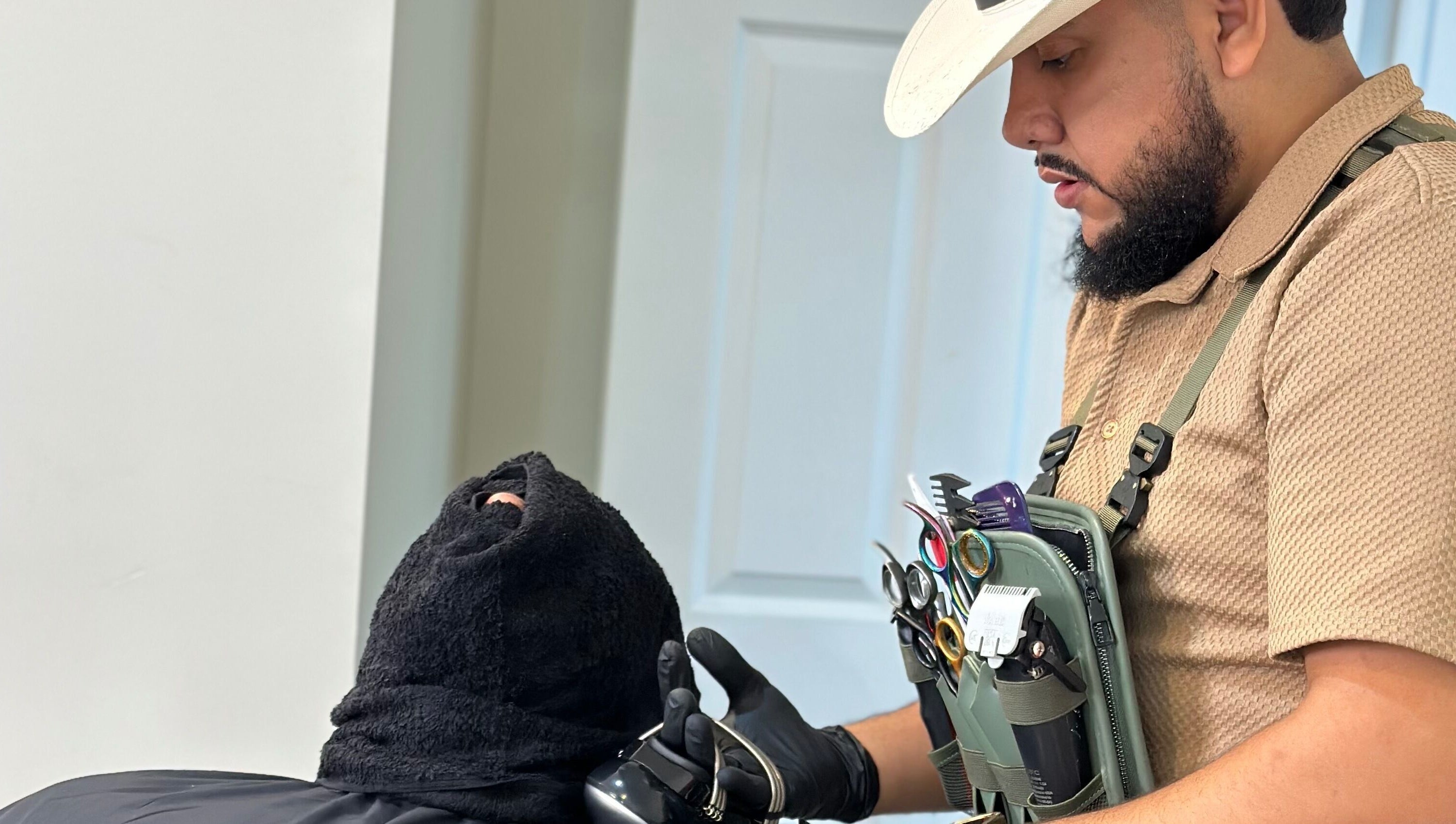 Barber grooming a client at Charro Barber, Montebello, California, US, showcasing professional tools.