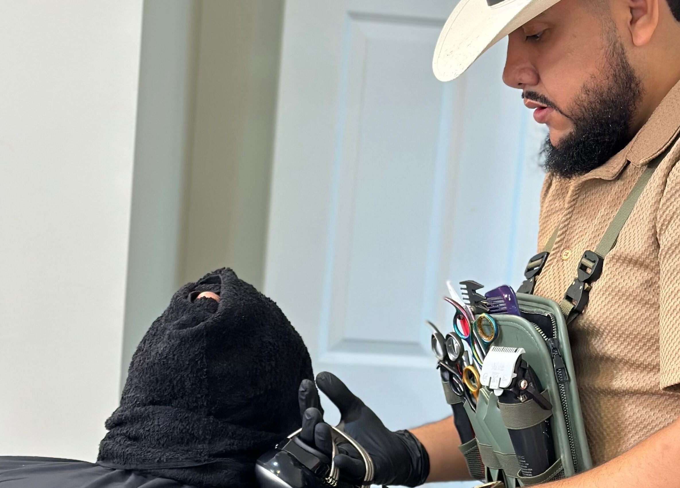 Barber grooming a client at Charro Barber, Montebello, California, US, showcasing professional tools.