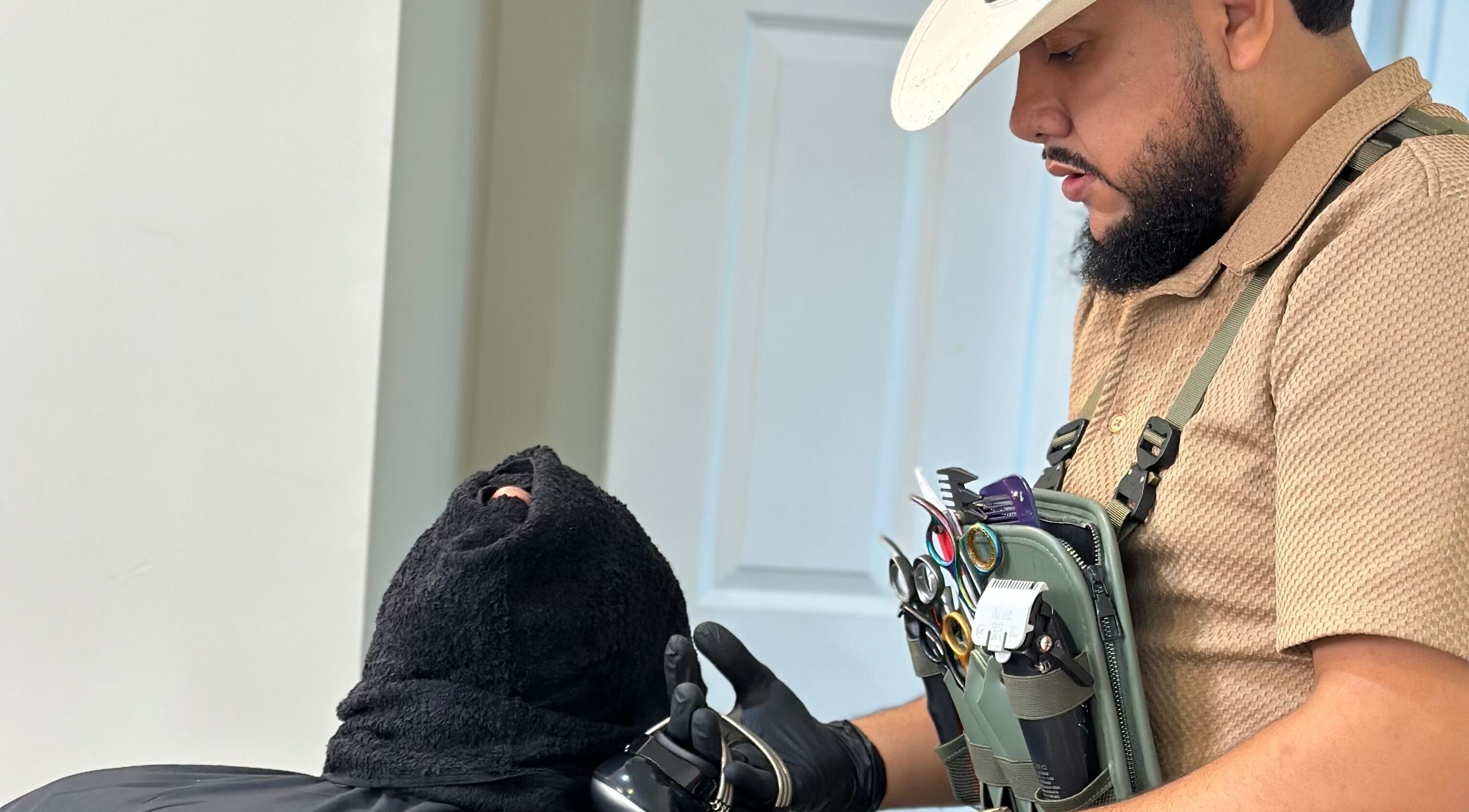 Barber grooming a client at Charro Barber, Montebello, California, US, showcasing professional tools.