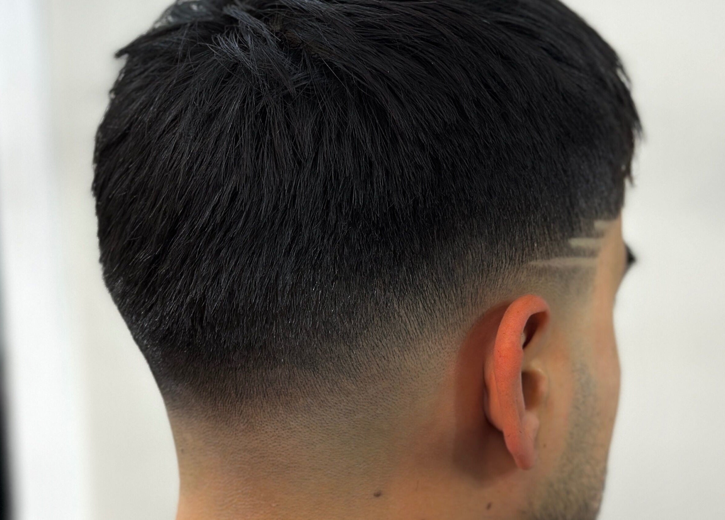 Stylish fade haircut with design at Charro Barber in Montebello, California, US.