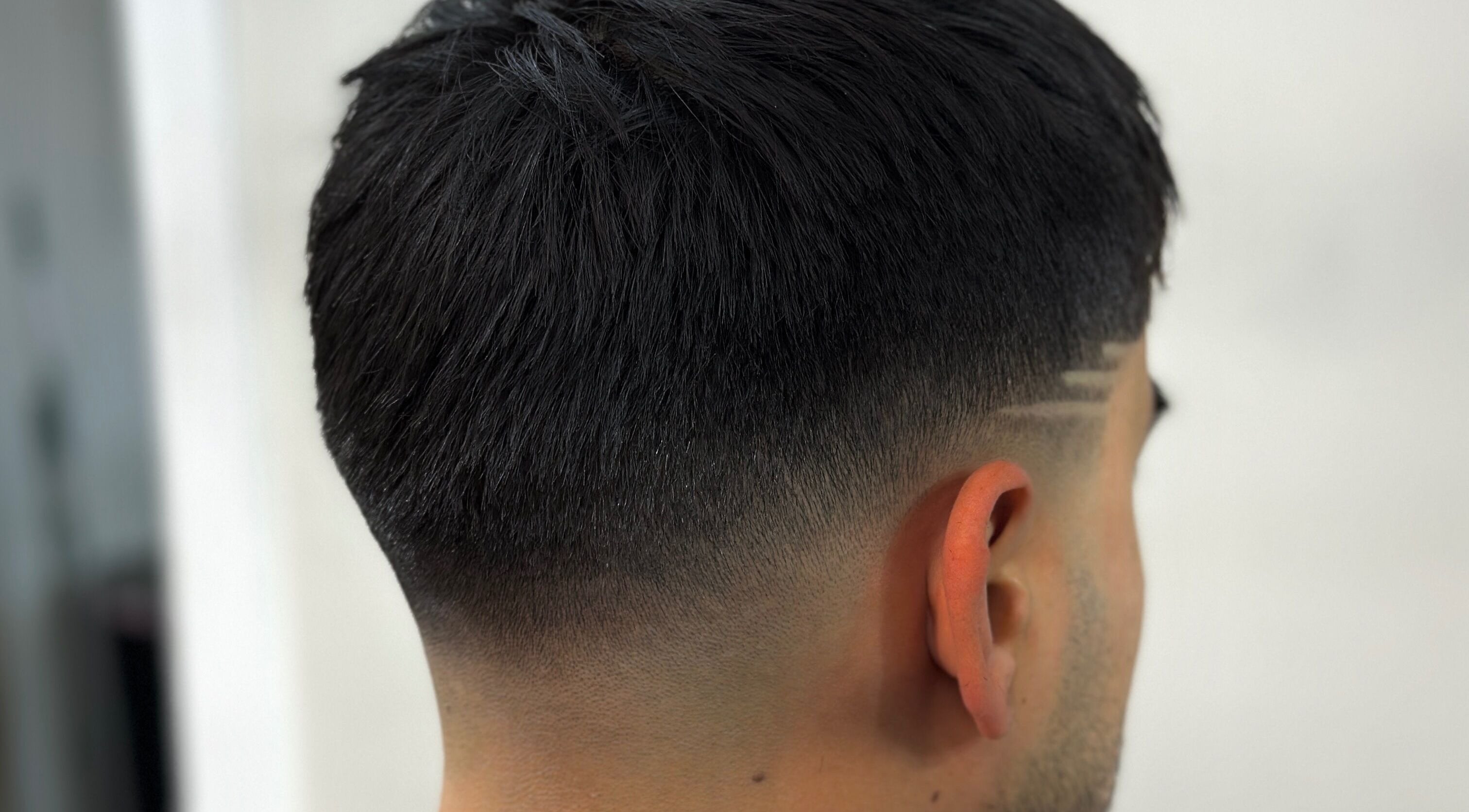 Stylish fade haircut with design at Charro Barber in Montebello, California, US.