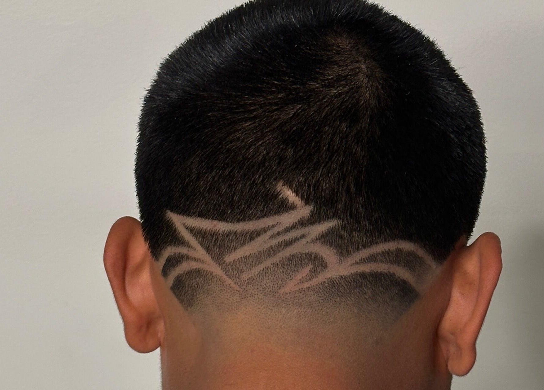 Intricate hair design at Charro Barber, Montebello, California, US showcasing a buzz cut with unique patterns.