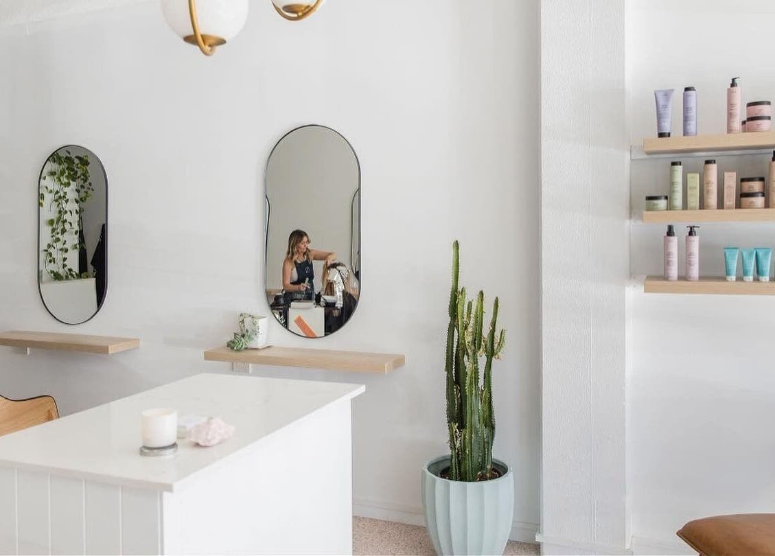 Stellar Salon's modern interior with mirrors, chic seating, and shelves of products in Coolangatta, Queensland, AU.