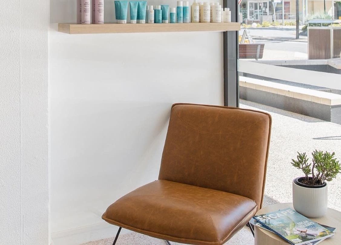 Cozy waiting area at Stellar Salon, Coolangatta, Queensland, AU showcasing a stylish chair and beauty products.
