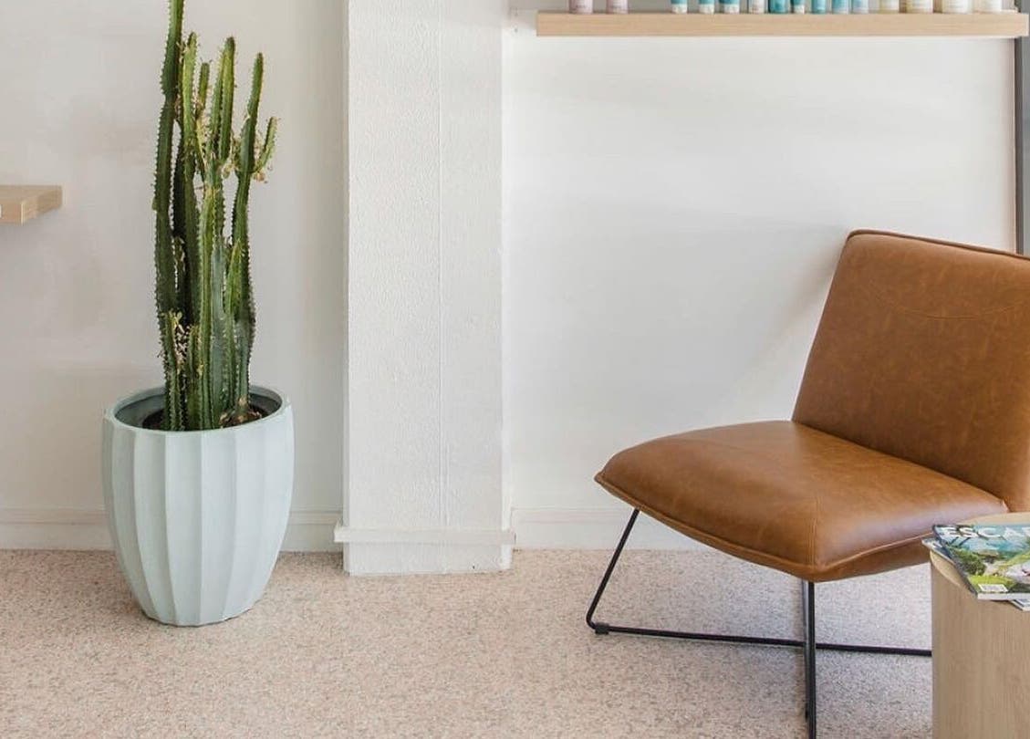 Modern waiting area with leather chair and cactus at Stellar Salon, Coolangatta, Queensland, AU.