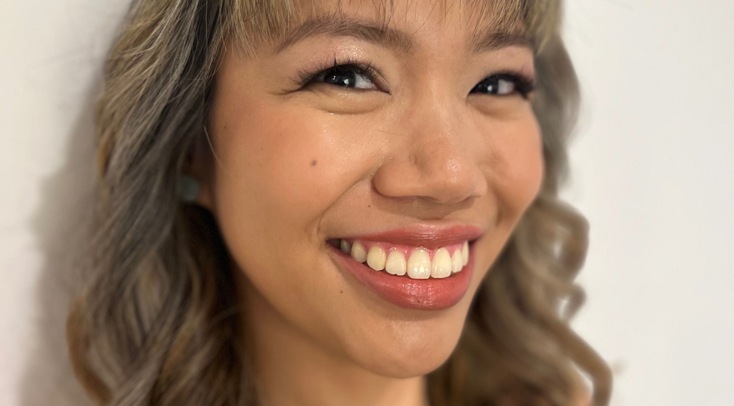 Client smiling with styled hair at Jamie Elle Hair Makeup Extensions in Southport, Queensland, AU.