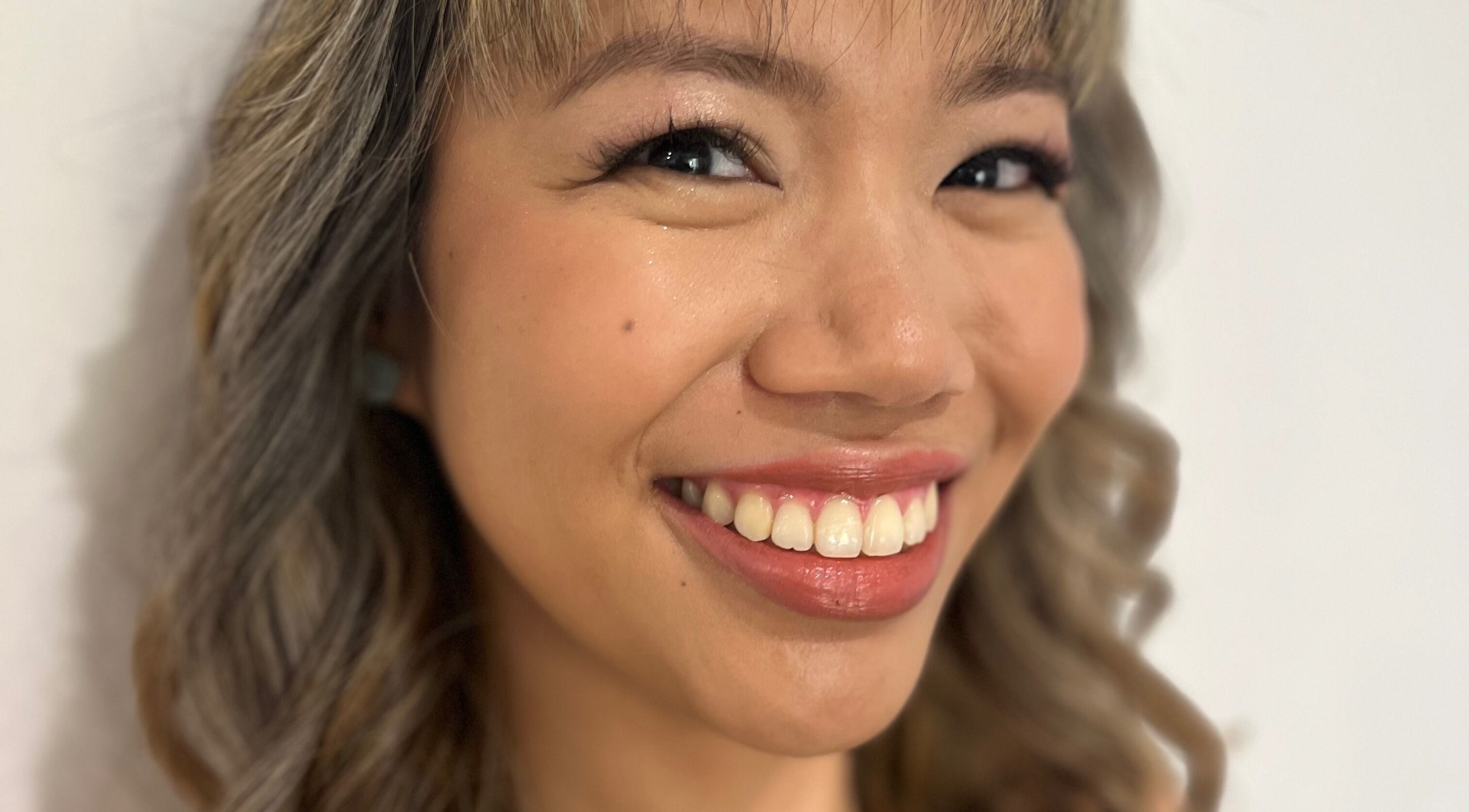 Close-up of a smiling customer with styled hair at Jamie Elle Hair & Makeup (Mobile), Southport, Queensland, AU.