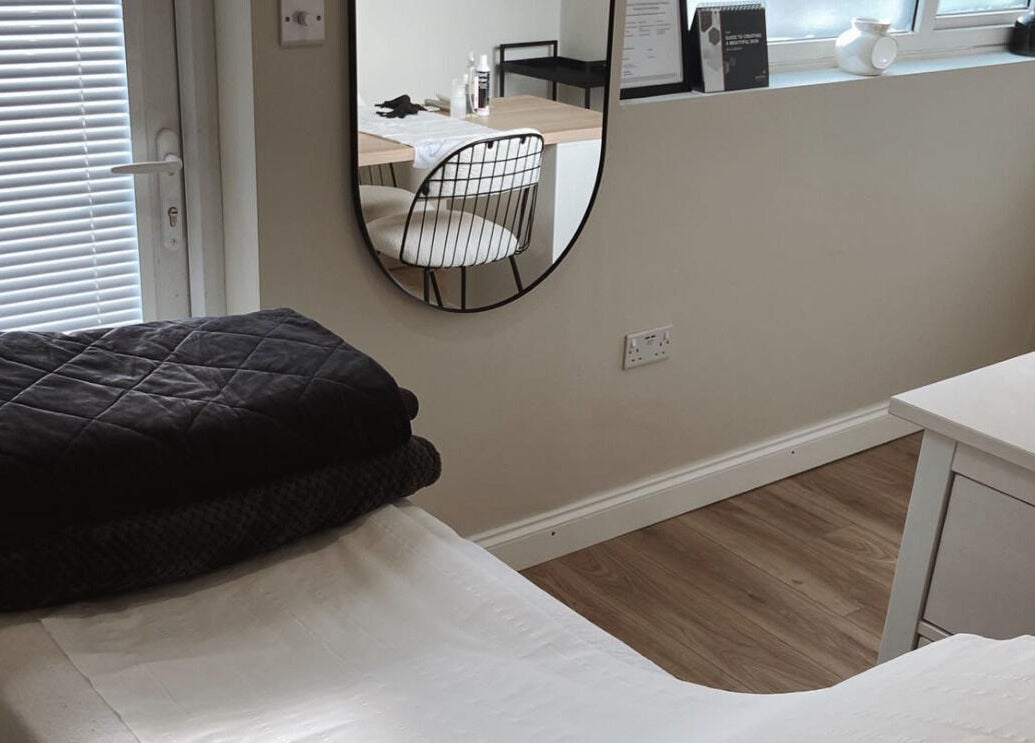 Tranquil salon room at Bare Faced by Elle, Middlesbrough, England, GB, with a treatment table and mirror.
