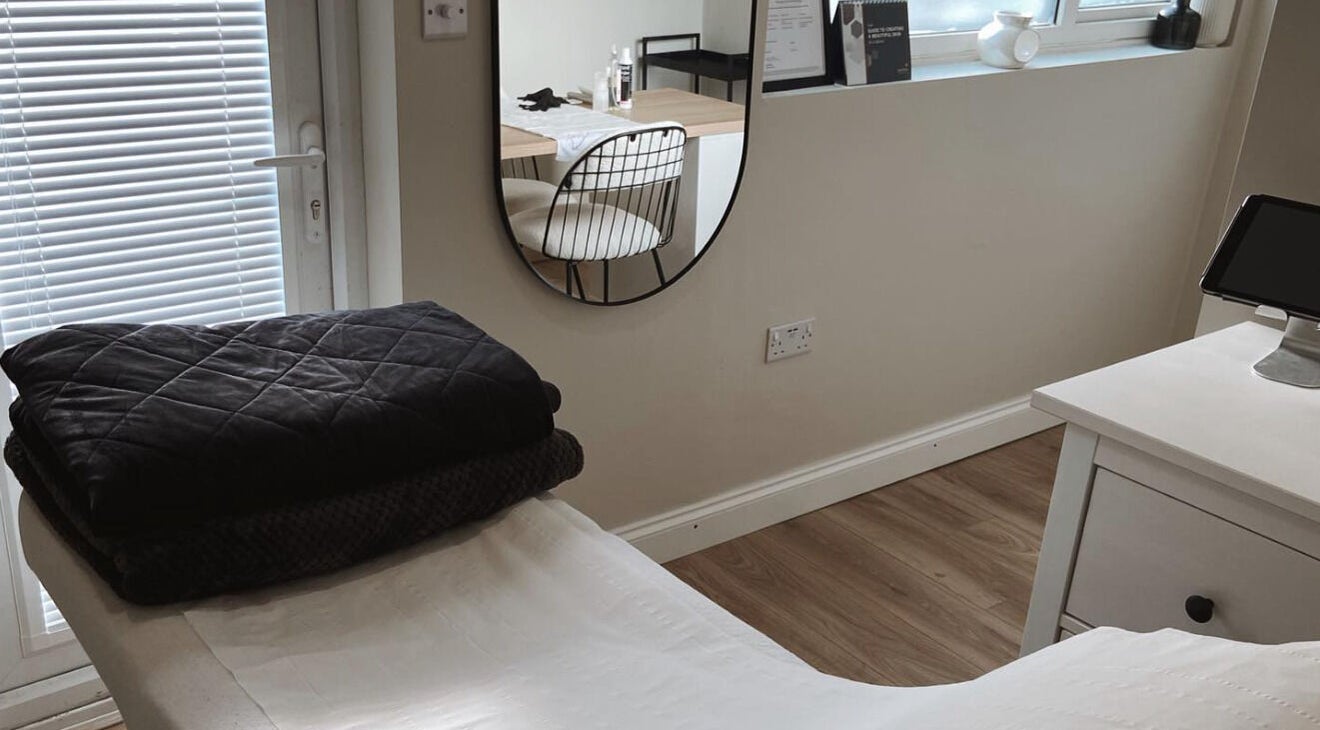 Tranquil salon room at Bare Faced by Elle, Middlesbrough, England, GB, with a treatment table and mirror.