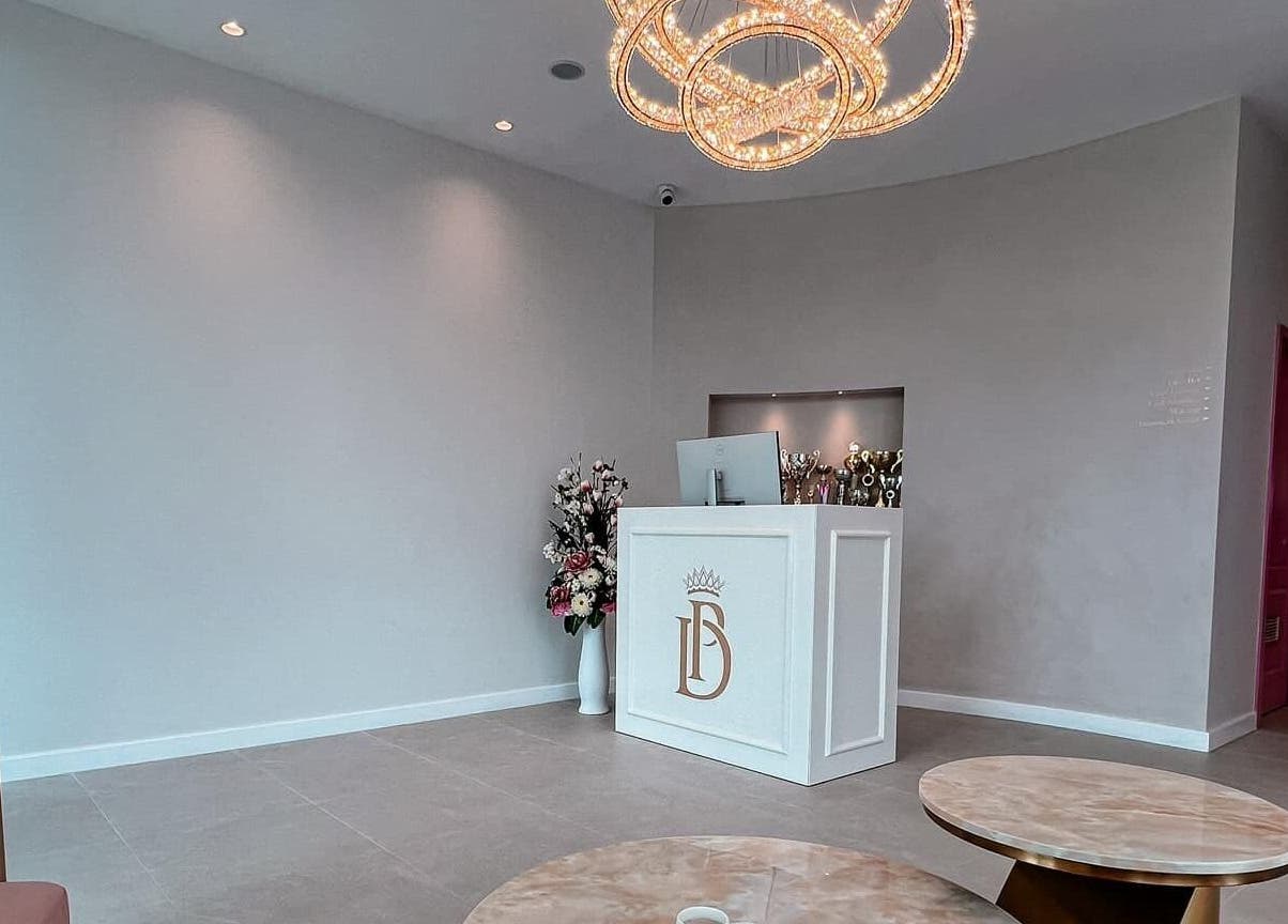 Reception area at All About You BodySculpting Perth in Mount Pleasant, WA, featuring a chic chandelier and floral decor.