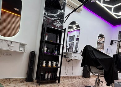 Interior moderno de YN.Barber en Cartagena, Región De Murcia, ES con iluminación púrpura y sillas de peluquería.
