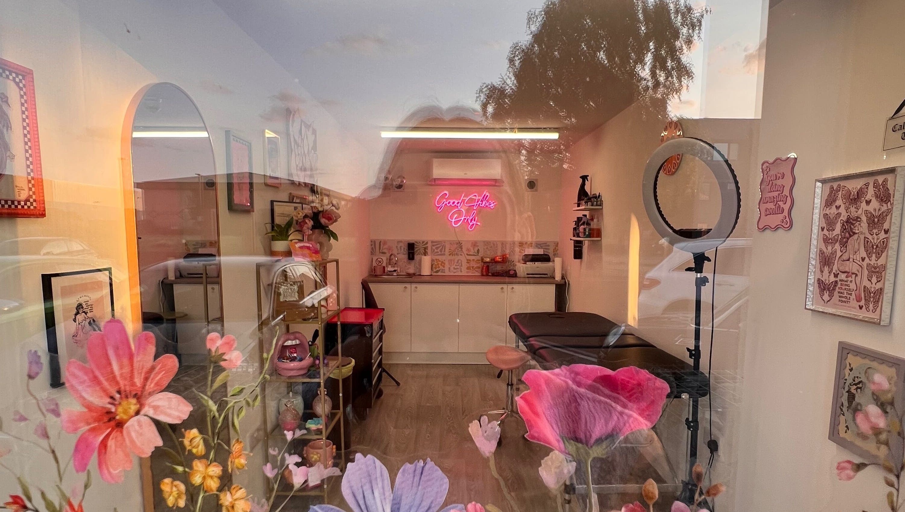 Chloe Duncan Tattoo studio interior with floral decor and neon sign in Rochester, England, GB.