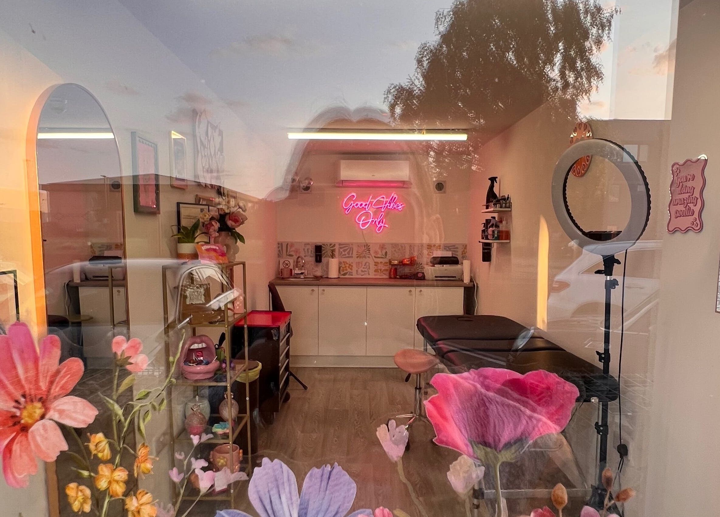 Chloe Duncan Tattoo studio interior with floral decor and neon sign in Rochester, England, GB.