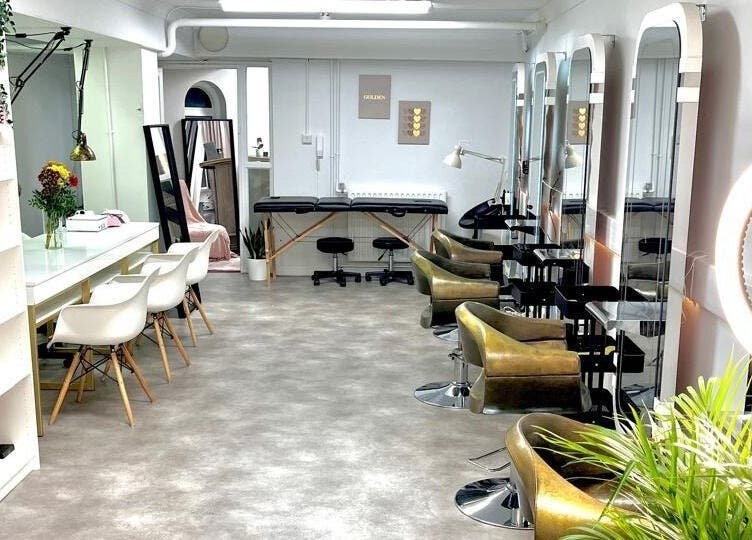 Interior do Studio Zaina em Dublin, IE, com cadeiras de salão e espelhos elegantes.