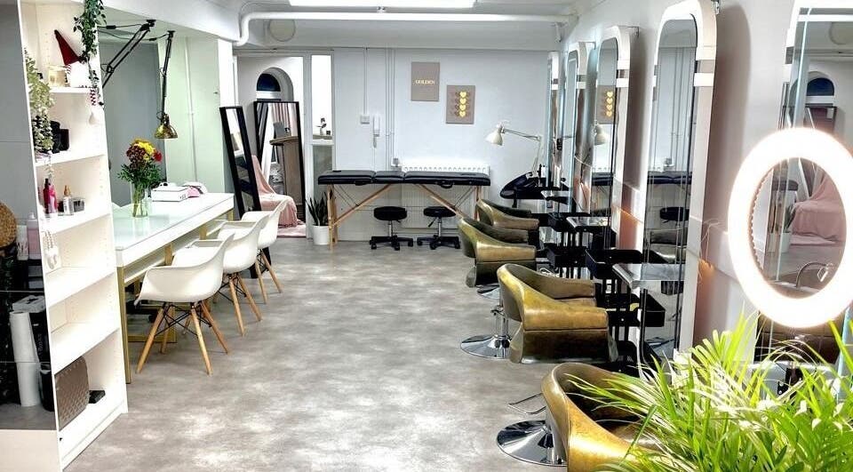 Interior do Studio Zaina em Dublin, IE, com cadeiras de salão e espelhos elegantes.