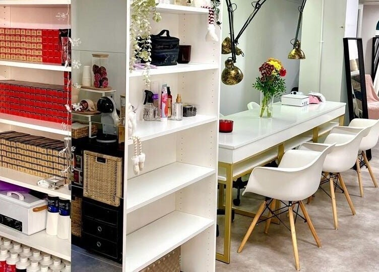 Interior moderno do Studio Zaina, Dublin, County Dublin, IE, com cadeiras brancas e prateleiras organizadas.